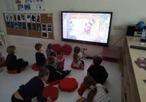 Dzieci oglądają "Opowieść wigilijną Myszki Miki".